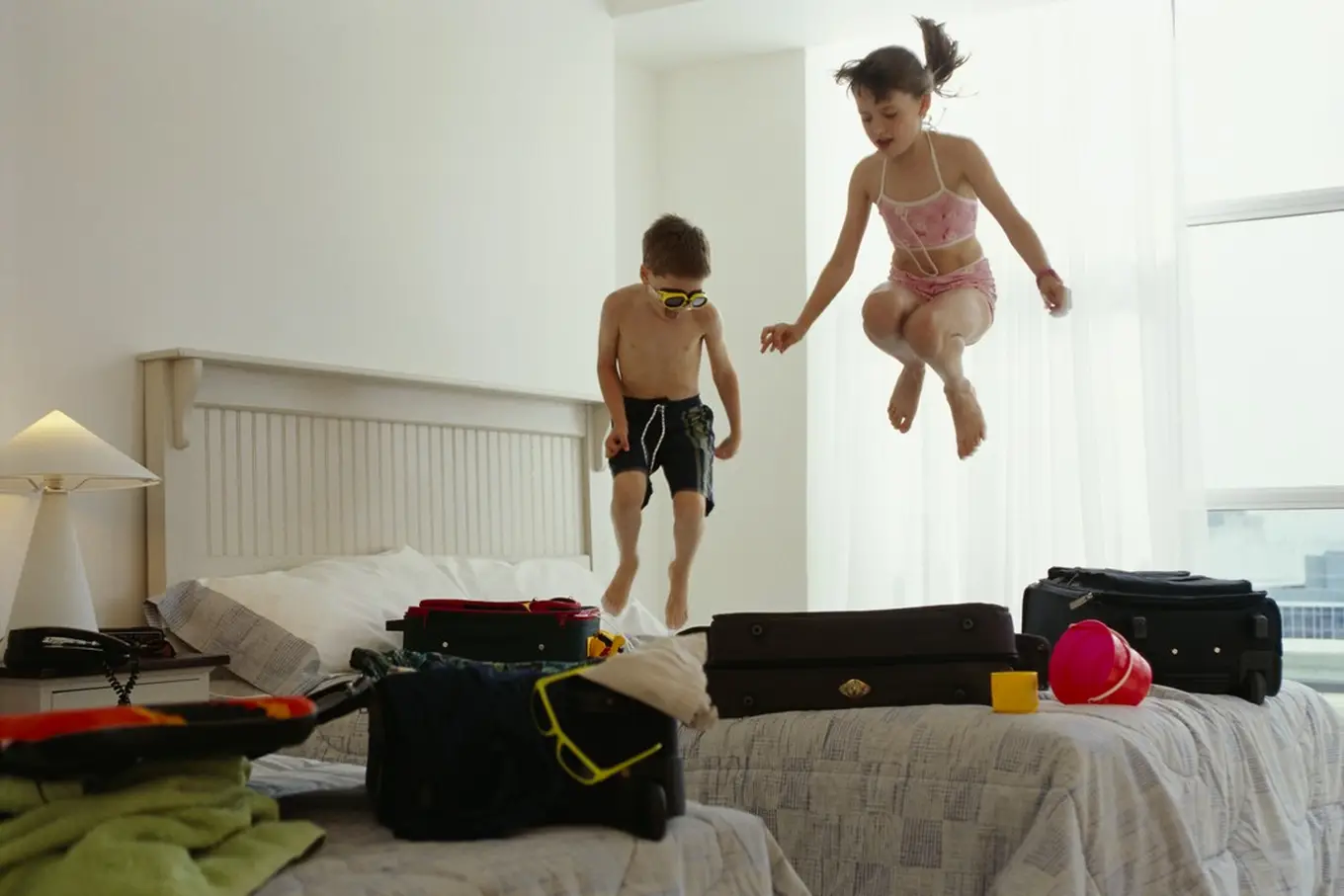 dzieci skaczące po łóżku w hotelu